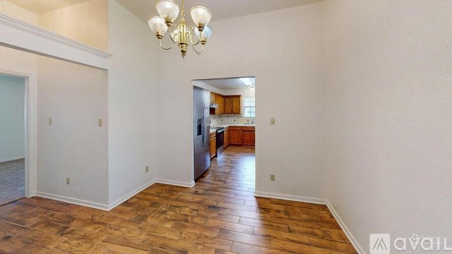 A room with wooden floors and a chandelier is available for rent.