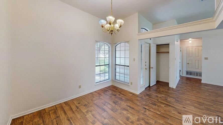 A room with wooden floors and a chandelier.
