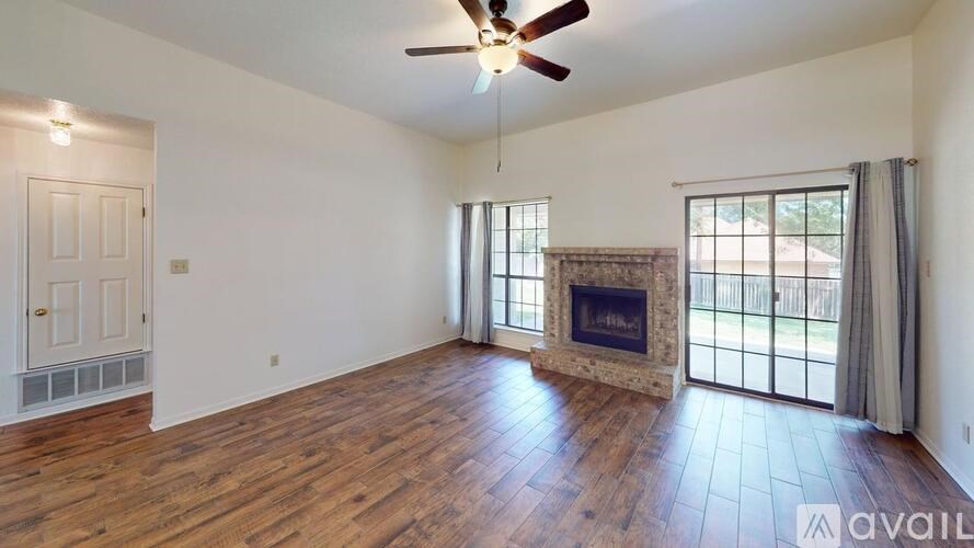 A spacious room with a fireplace and sliding glass doors.