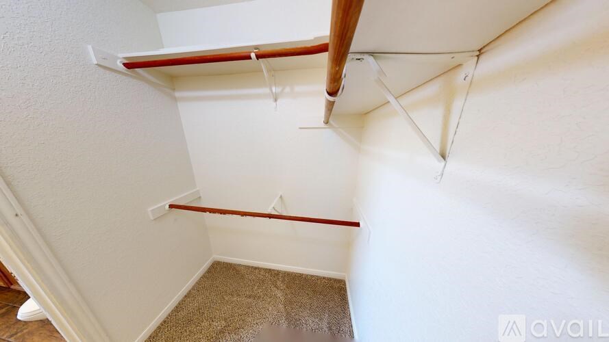 A room with a carpeted floor and a ceiling fan.