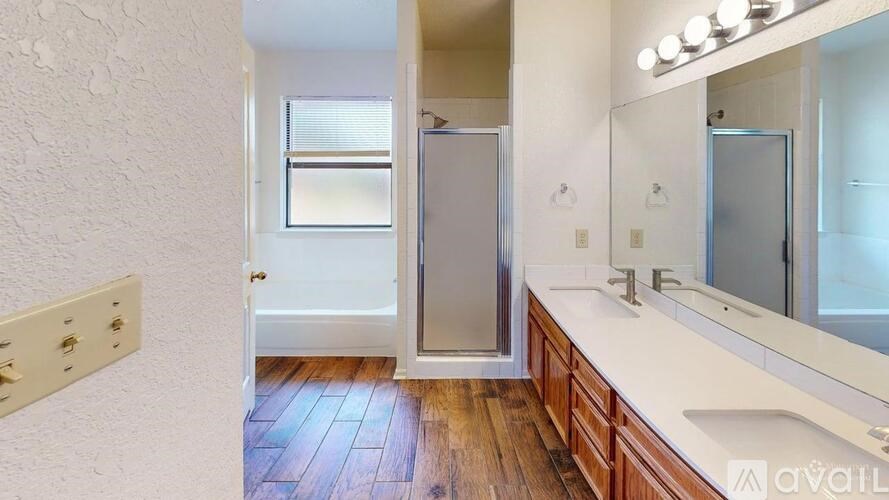 A bathroom with a white countertop and a wooden floor.