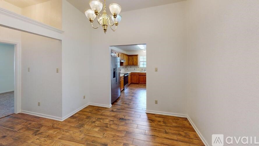A room with wooden floors and a chandelier.