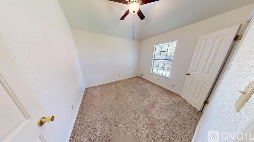 A room with a ceiling fan and a window.