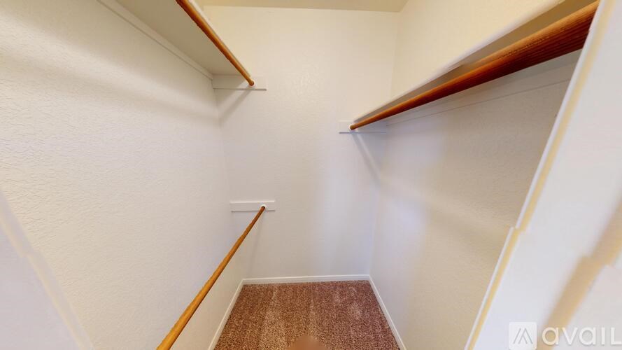 A hallway with a wooden floor and white walls.