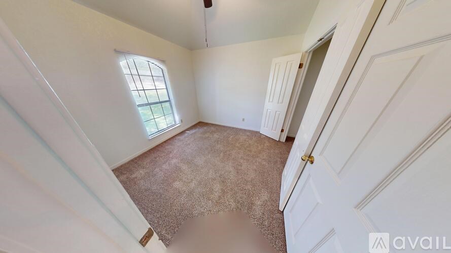 A room with a carpeted floor and a window.