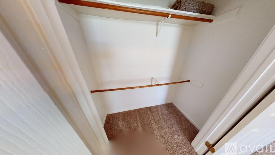 A small, empty room with a brown carpet and white walls.