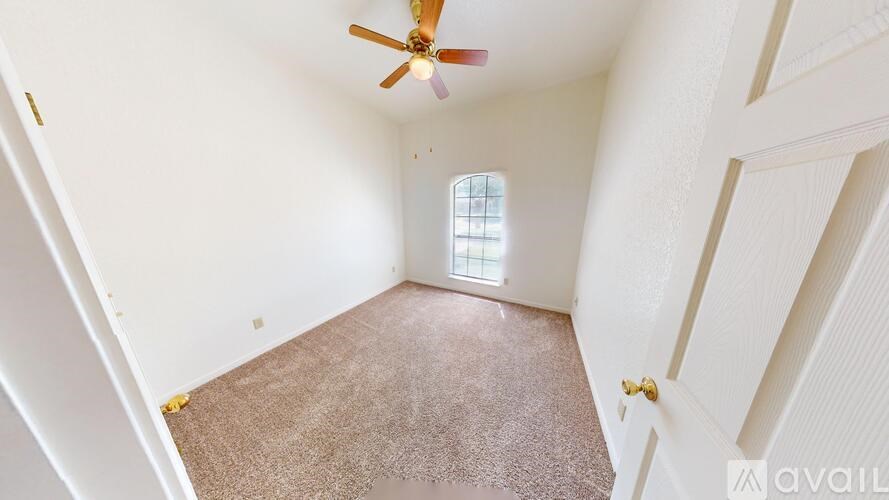 A room with a ceiling fan and a window.