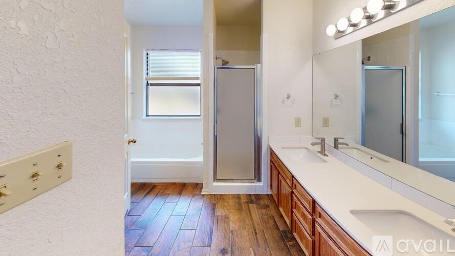 A bathroom with a white countertop and a wooden floor.