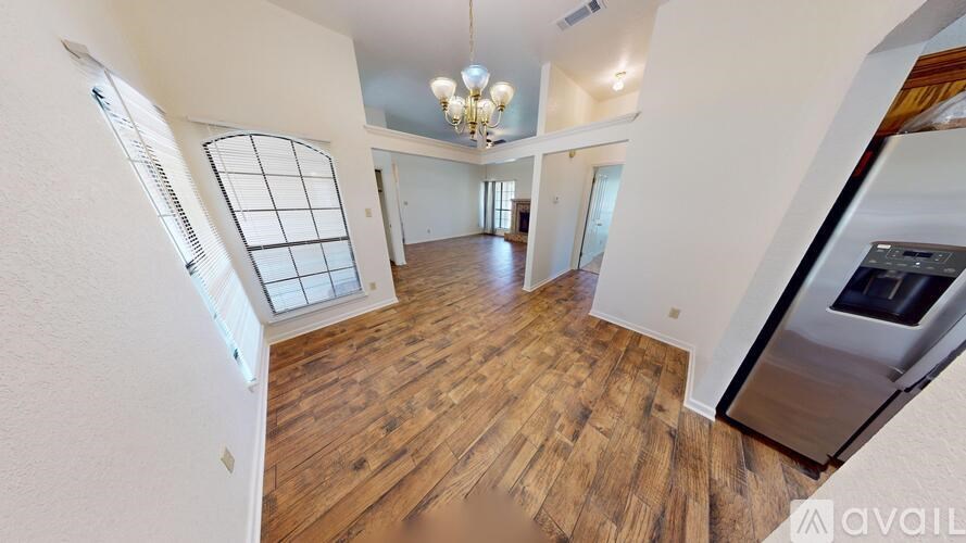 A spacious room with a ceiling fan and two windows.