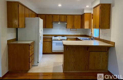 A kitchen with wooden cabinets and a white refrigerator.