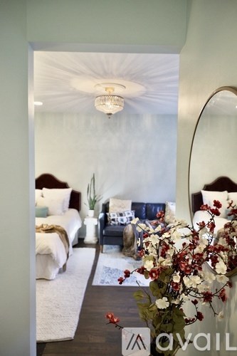 A bedroom with a bed, a nightstand, and a mirror.