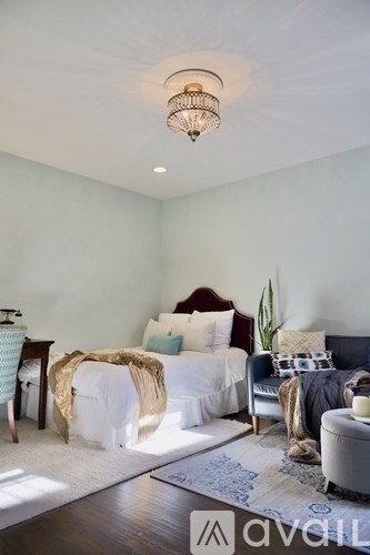 A bedroom with a bed, a couch, and a rug.