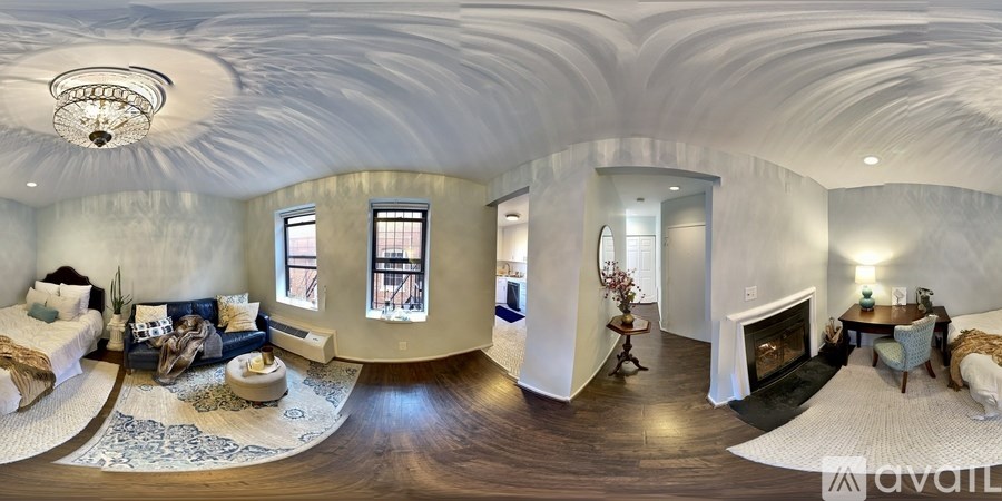 A large, white, circular room with a fireplace and a bed.