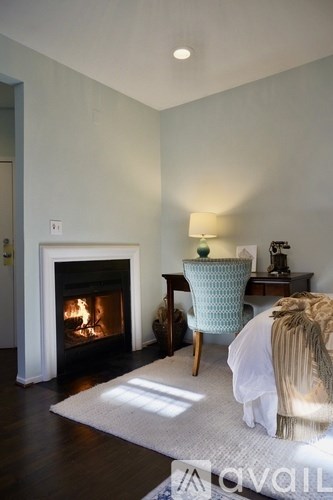 A cozy living room with a fireplace and a chair.