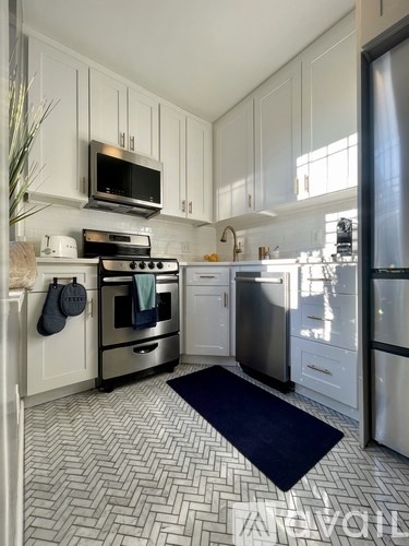A kitchen with a black stove top oven and a black microwave above it.