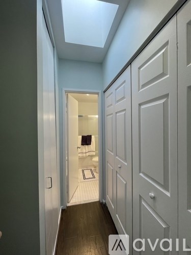 A hallway with a skylight and a door on the left.
