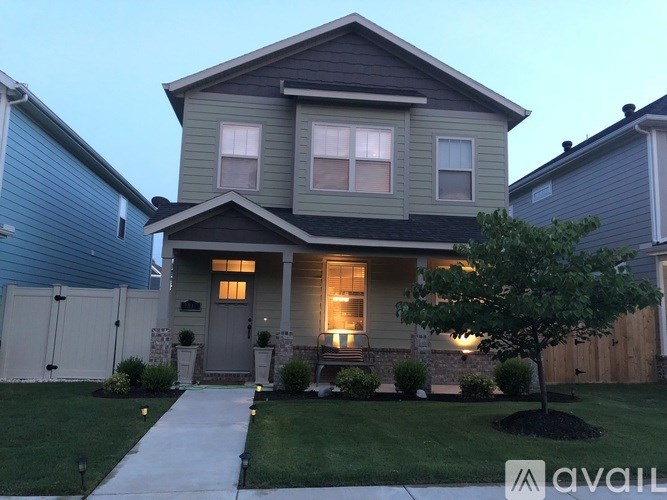 A house with a front yard and a tree.