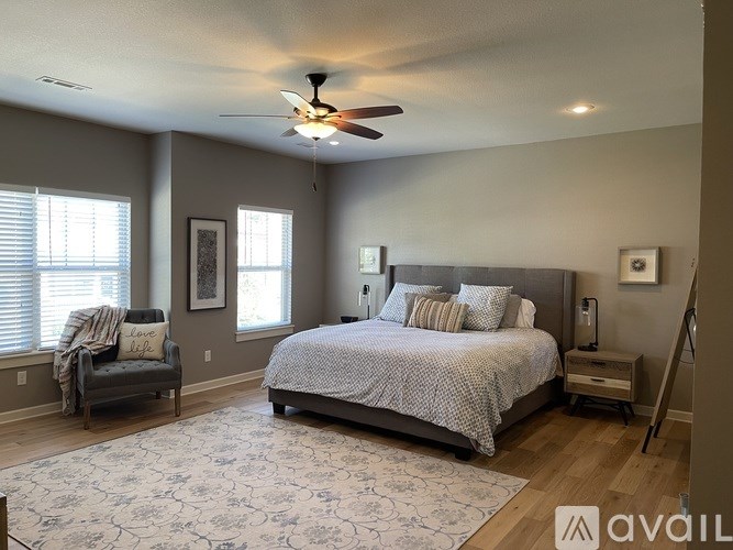 A bedroom with a large bed and a ceiling fan.