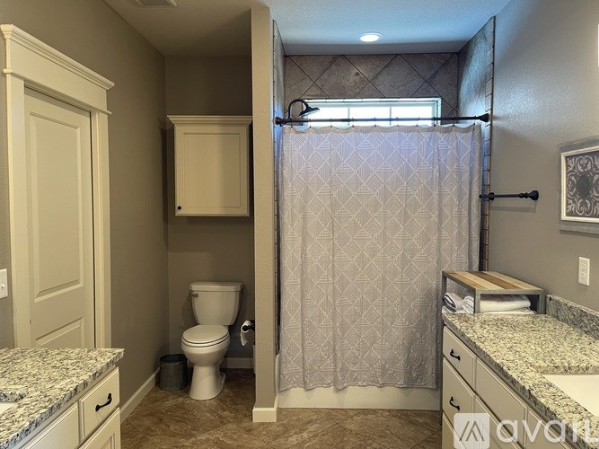 A bathroom with a toilet, sink, and shower.
