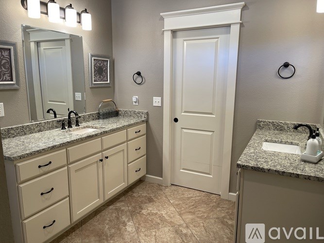 A bathroom with a sink, mirror, and cabinets.