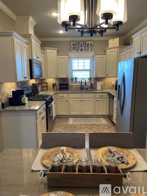 A kitchen with a large island in the middle and a sign that says "EAT" above the stove.