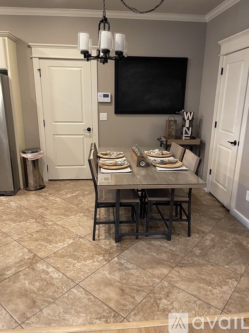A dining room with a table set for four.