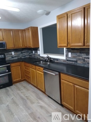 A kitchen with wooden cabinets and a black countertop.