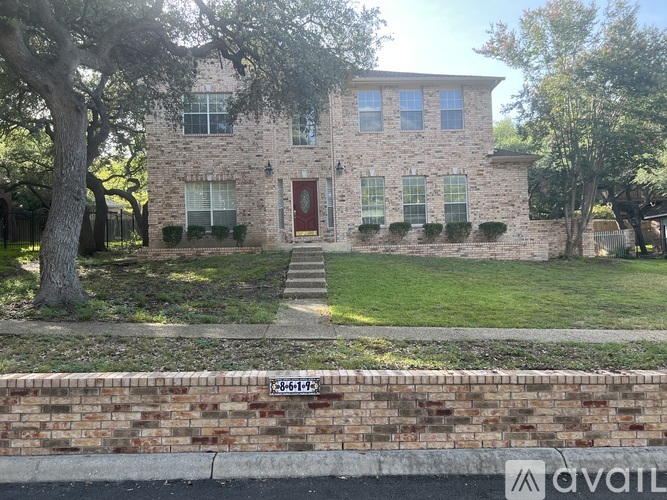 A house with a red door and a brick wall in front.