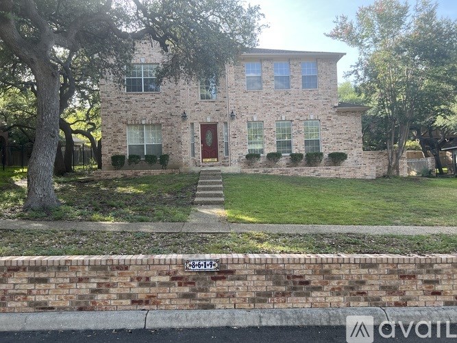 A house with a red door and a brick wall in front.