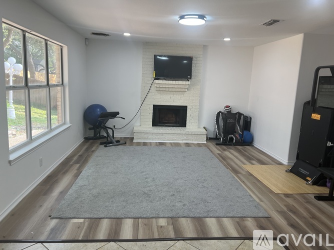 A living room with a fireplace and a television above it.