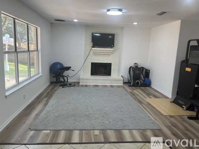 A living room with a fireplace and a television above it.