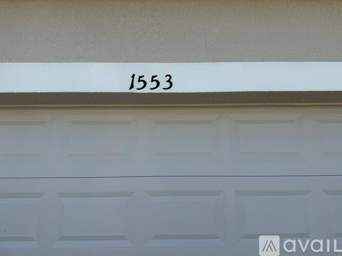 A white garage door with the number 1553 on it.