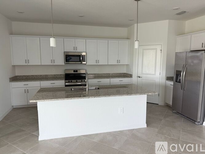 A kitchen with white cabinets and a granite countertop.