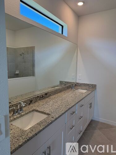A bathroom with granite countertops and a large mirror.