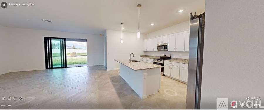 A modern kitchen with white cabinets and a large island.