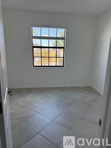 A room with a window and tiled floor.