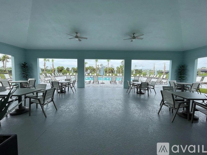 A patio with tables and chairs and a ceiling fan.