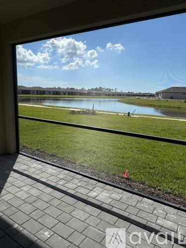 A view from a window looking out at a lake and a building.
