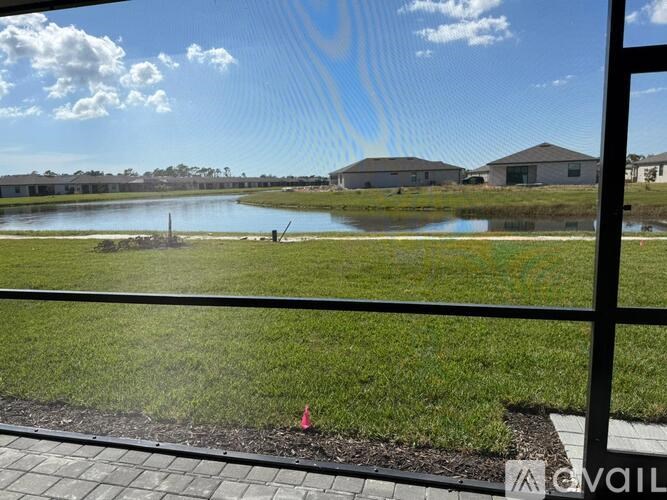 A view of a pond through a window with a metal frame.