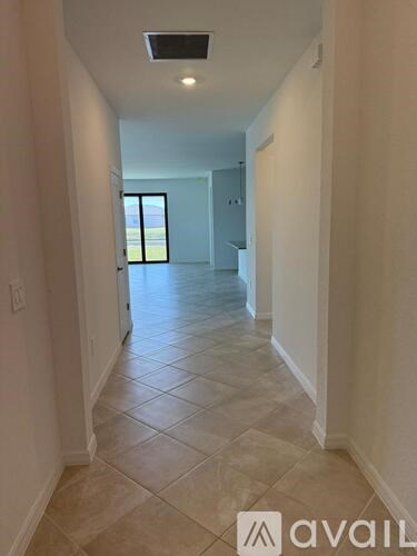 A hallway with tiled flooring and a skylight.