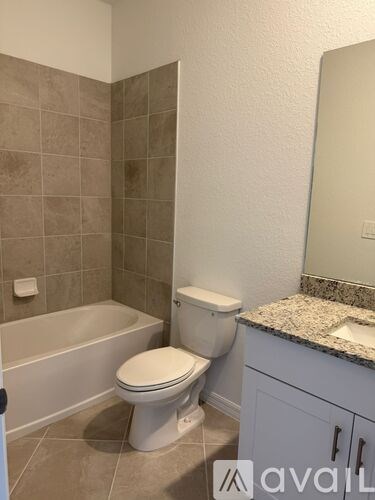 A bathroom with a toilet, sink, and bathtub.