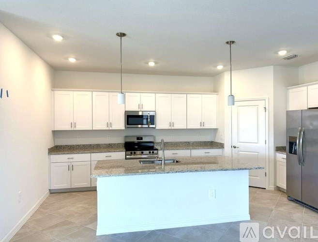 A kitchen with granite countertops and stainless steel appliances.