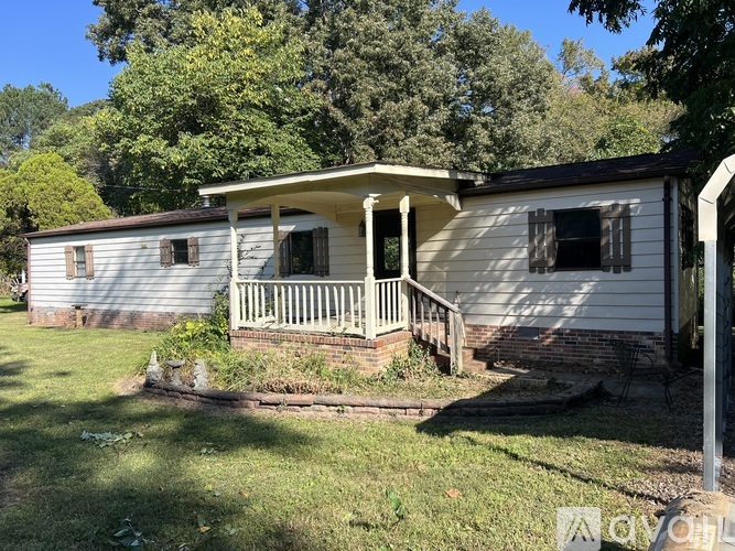 A small white house with a porch and a covered patio.