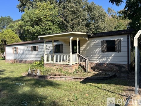 A small white house with a porch and a covered patio.