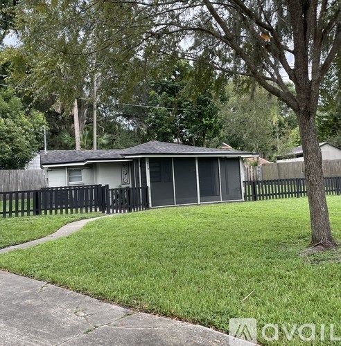 A house with a grey roof and a black fence.