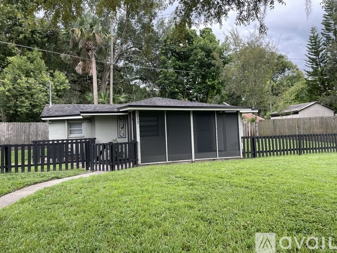 A house with a grey roof and a black fence.