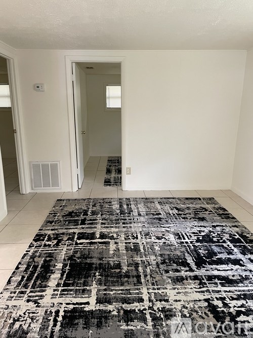 A black and white rug with a geometric pattern is on the floor of a room.