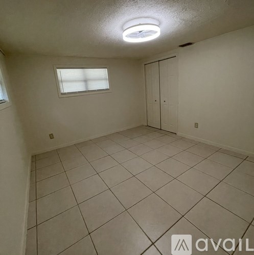A room with white walls, a window, and a tiled floor.