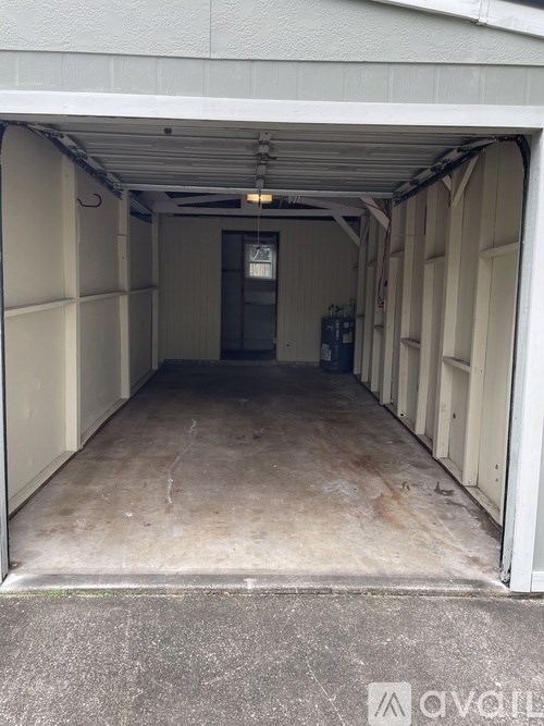 A white garage door is open to reveal a dark interior.