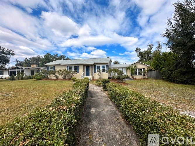 A house with a blue sky and clouds in the background.
